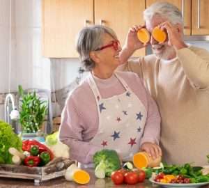 a female senior female cooking with a senior male