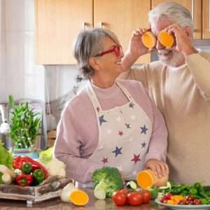 a female senior female cooking with a senior male