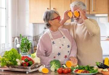 a female senior female cooking with a senior male