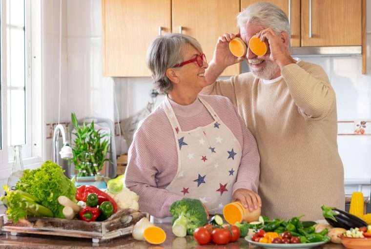 a female senior female cooking with a senior male